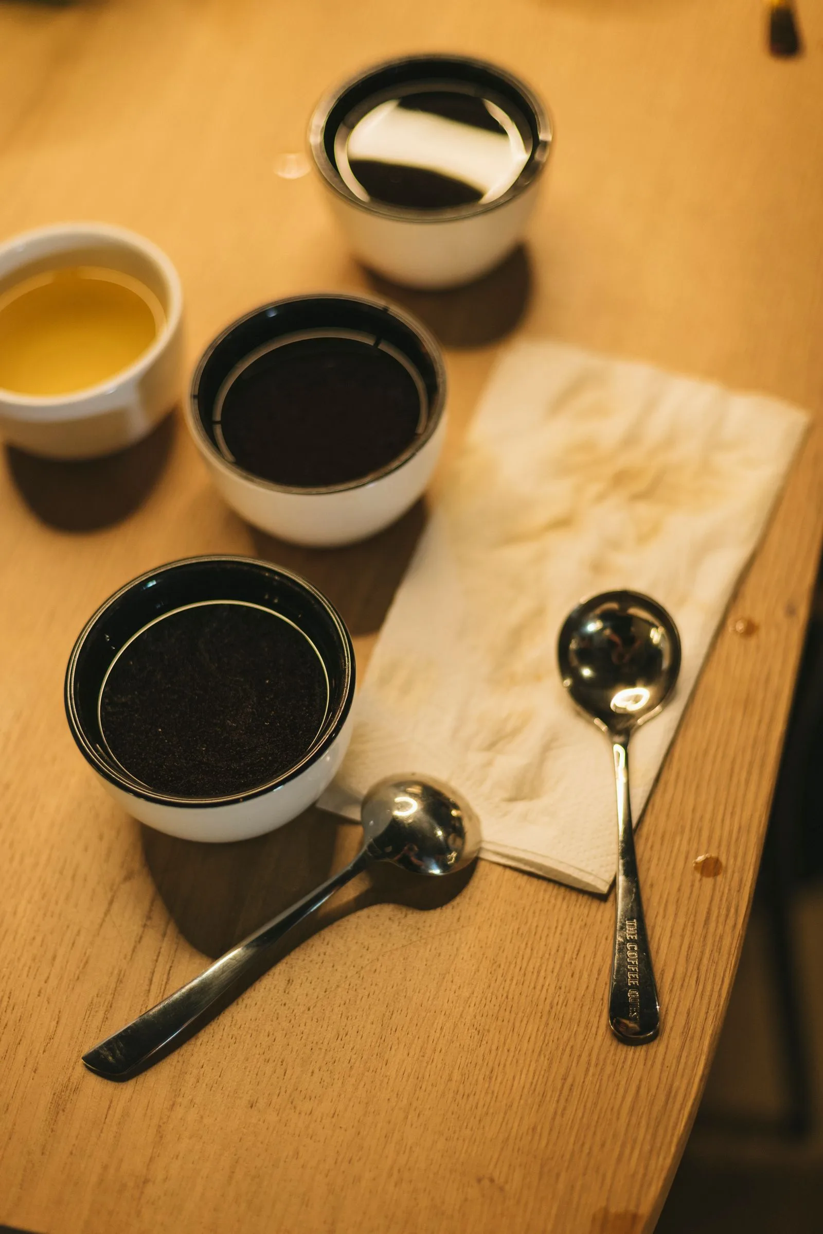 Cupping bowls and tasting spoons on a wooden table for a coffee blend consistency trial