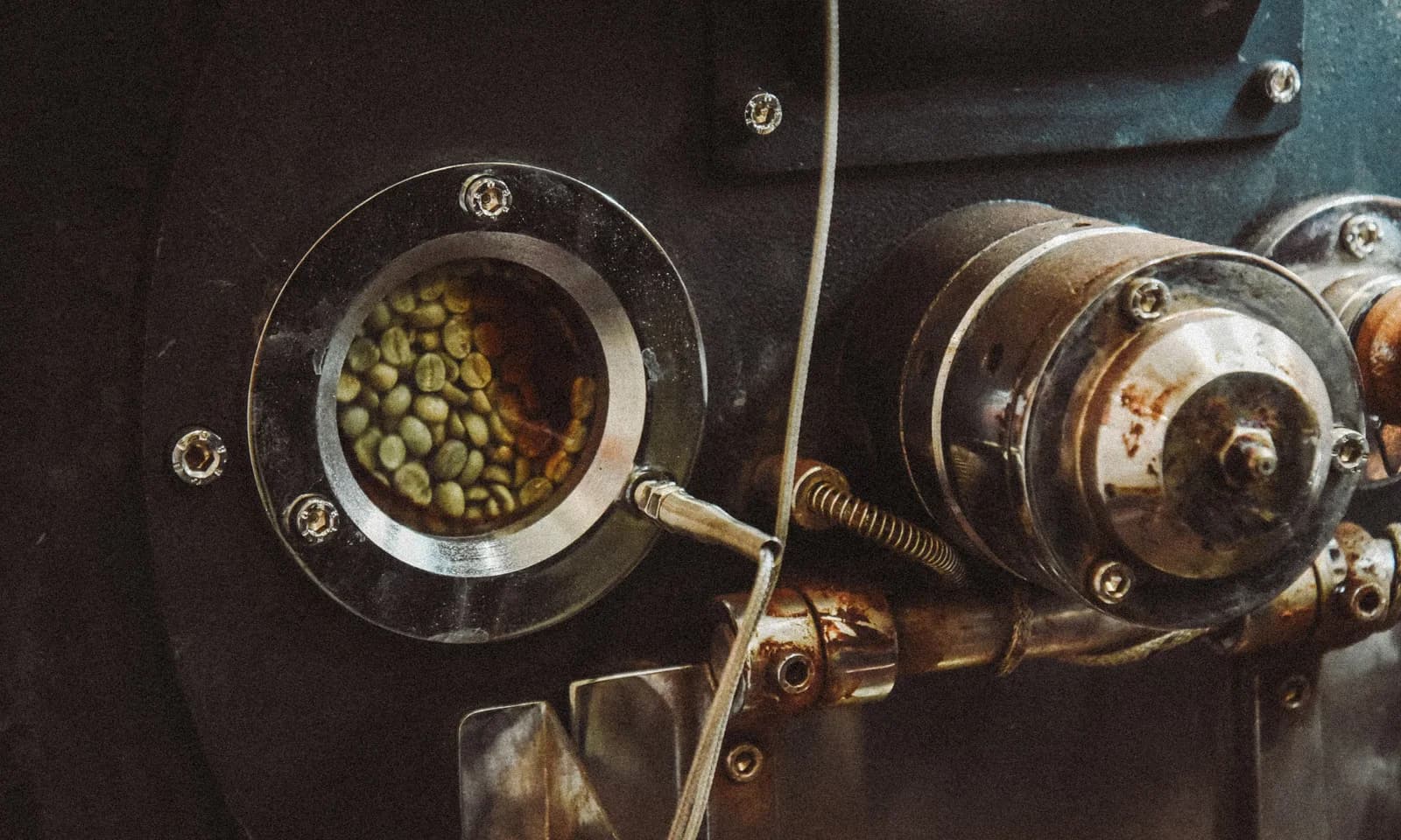 Green coffee beans turning in a sample roaster during a buyer quality evaluation