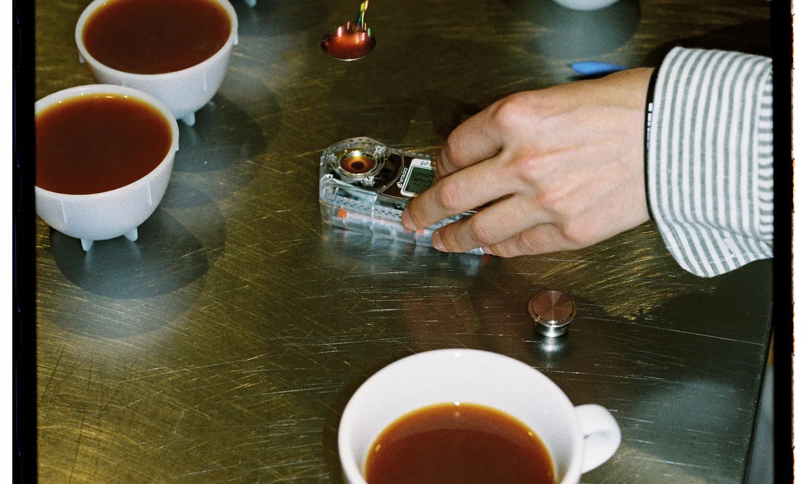 Coffee cupping calibration session with tasting bowls, spoon, timer, and score records